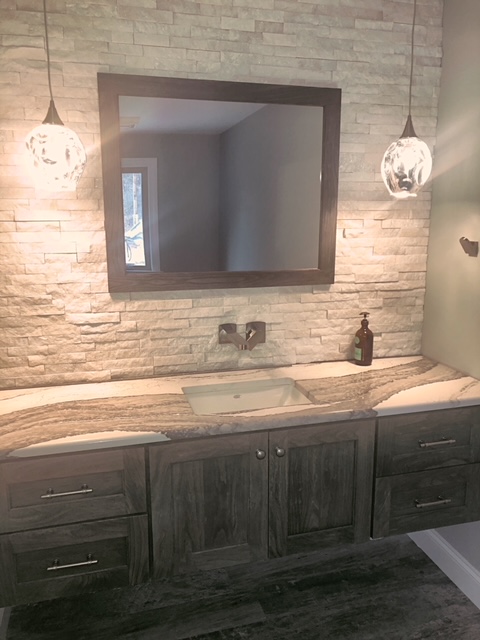Bathroom with stacked stone, floating vanity and pendant lights