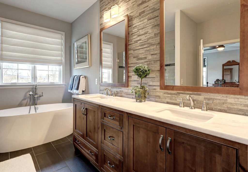 Bathroom with stacked stone wall, double vanity and soaking tub